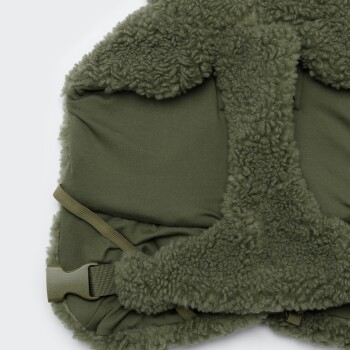 Nahaufnahme einer olivgrünen, mit Sherpa gefütterten Haustierweste mit seitlicher Kunststoffschnalle und elastischem Riemen.