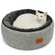 Ein gemütliches, rundes graues Katzenbett mit einem plüschigen Innenraum, mit einem Lederetikett. Eine weiße Katze hat sich bequem darin eingerollt.