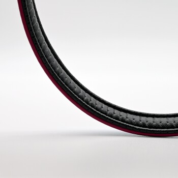 Eine Nahaufnahme einer schwarzen geflochtenen Haustierleine mit rotem Rand, die ihre Textur und ihr Design vor einem weißen Hintergrund zeigt.