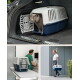 Graue Katze lugt aus blau-weißer Kunststoff-Transportbox im Kofferraum eines Autos; Einblendungen zeigen die Box beim Tierarzt und eine Frau, die sie trägt.