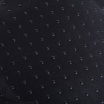 Nahaufnahme eines strukturierten schwarzen Stoffes mit kleinen, gleichmäßig verteilten Perforationen, wahrscheinlich verwendet für Haustierbekleidung oder -zubehör.