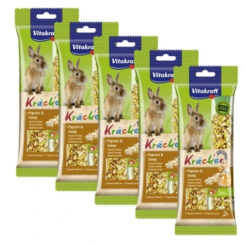 Fünf Pakete Vitakraft Kräcker für Kaninchen, mit Popcorn und Honig, mit einem Kaninchenbild und Text, der Vitamine und Mineralien hervorhebt.