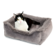 Ein gemütliches graues Haustierbett mit einem weichen, plüschigen Rand, in dem eine schwarz-weiße Katze bequem ruht.