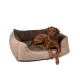 Ein brauner Hund liegt auf einem plüschigen, beige-braunen Haustierbett mit einem gesteppten Innenraum, auf dessen Seite der Text "TrendPet" steht.