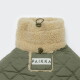 Olivfarbene, gesteppte Haustierjacke mit sandfarbenem Sherpa-Kragen und Knebelverschlüssen, weißer Aufnäher mit der Aufschrift PAIKKA.