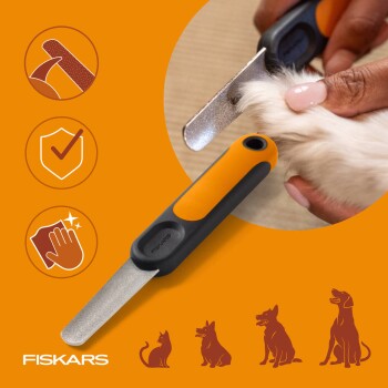 Orange-schwarze Fiskars-Nagelfeile für Haustiere, die an einer pelzigen Pfote verwendet wird; Pflegeicons und Haustiersilhouetten, Schriftzug 'FISKARS'.