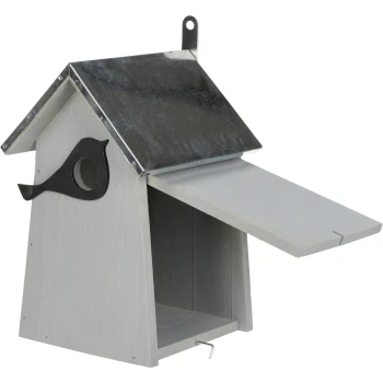 A wooden birdhouse with a metallic roof, featuring a bird silhouette design on the side and an open front door.