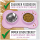 Rosa Futtermatte für Haustiere mit zwei Edelstahlschalen, mit Text über Sauberkeit und enthaltenen Einsätzen für verschiedene Schalen Größen.