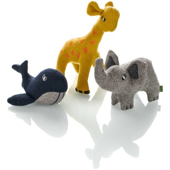 Drei bunte plüschige Tier-Spielzeuge: eine gelbe Giraffe, ein grauer Elefant und ein blauer Wal, auf einer reflektierenden Oberfläche präsentiert.