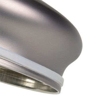 Gros plan sur un bol de nourriture pour animaux en métal élégant, avec un bord lisse et arrondi et une base en silicone blanche pour la stabilité.