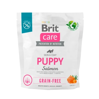 Verpackung für Brit Care Puppy Salmon Hundefutter, mit weißem Hintergrund, pinkem Text und Symbolen für getreidefrei und ernährungsphysiologische Vorteile.