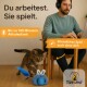 Eine verspielte Katze interagiert mit einem blau-weißen Spielzeug, während eine Person an einem Schreibtisch arbeitet. Der Text hebt die Batterielebensdauer von 1,5 Stunden und interaktives Spielen hervor.