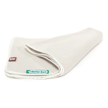 Ein gefaltetes beiges Haustierdecke mit einem weißen Rand, das ein grünes "Doctor Bark"-Logo und ein kleines rotes Etikett zeigt.