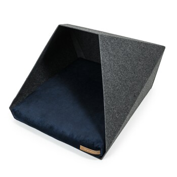 Ein modernes Haustierbett mit einem dreieckigen Filz-Außenbereich und einem plüschigen, marineblauen Kissen innen, entworfen für Komfort und Stil.