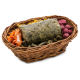 Ein geflochtener Korb, gefüllt mit verschiedenen Haustierleckereien, darunter ein grüner Stock, orangefarbene Streifen und runde lila Snacks.