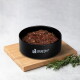 Schwarze Schale mit Aufschrift „LIEBESGUT – WEIL LIEBE GUT TUT“, gefüllt mit Nassfutter, auf einem Holzbrett mit Rosmarinzweigen.