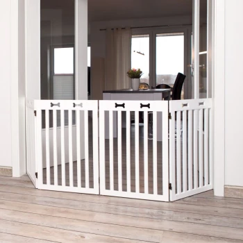 Weißes Holzhaustiergitter mit knochenförmigen Akzenten, positioniert in einem modernen Innenraum, der einen Essbereich von einem anderen Raum trennt.