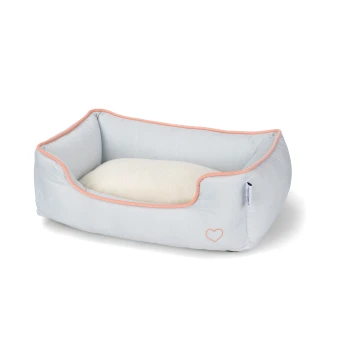 Jasnoniebieskie legowisko dla zwierząt z miękką białą poduszką, z różowym wykończeniem i małym logo serca po boku.