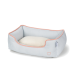 Lit pour animaux de compagnie bleu clair avec un coussin blanc doux, présentant une bordure rose et un petit logo en forme de cœur sur le côté.