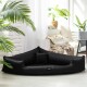 Ein stilvolles schwarzes Haustierbett in dreieckiger Form mit einem kleinen Kissen, das in einem hellen Raum mit Pflanzen und gemütlicher Dekoration platziert ist.