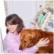 Person im rosa Hemd hält eine Tüte Nutriment Hundesnacks und umarmt einen Golden Retriever in einem Zoofachgeschäft.