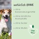 Ein glücklicher Hund sitzt in einem Blumenfeld neben einem grünen Schild mit der Aufschrift "natürlich OHNE" und einem Herzlogo für "100% Natur."
