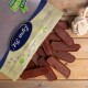 Eine Tüte mit Haustierleckereien mit der Aufschrift "Petra Set", die mehrere Streifen weicher, fleischiger Snacks auf einer Holzoberfläche auskippt, mit einem Seilspielzeug in der Nähe.