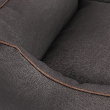 Nahaufnahme eines dunkelgrauen Haustierbettes mit einer strukturierten Oberfläche und braunen Kanten.