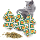 Eine graue Katze spielt mit sechs bunten pyramidenförmigen Katzenminze-Spielzeugen, mit getrockneter Katzenminze, die davor verstreut ist.