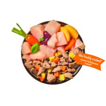 Schale mit rohen Hühnerstücken und gekochtem Fleisch mit Karotten und Kartoffeln; orange Etikett mit der Aufschrift 'like freshly cooked* / comme fraîchement cuisine*'.