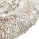 Gros plan d'un lit pour animaux doux et moelleux en beige et crème, mettant en valeur sa texture pelucheuse et sa forme ronde.