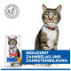Getigerte Katze mit rotem Halsband neben einer Katzenfuttertüte; Banner mit der Aufschrift 'REDUZIERT ZAHNBELAG UND ZAHNSTEINBILDUNG'.