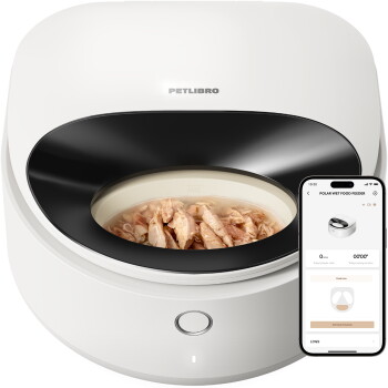 Katze frisst aus einem beigen Polar Smart Nassfutterspender mit einem schwarzen Spender daneben auf einem Holzboden.
