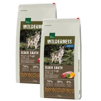 Zwei Säcke Real Nature Wilderness Black Earth Hundefutter, jeweils 12 kg, mit einem Wolf auf der Vorderseite und dem Hinweis "70 % Fleisch, 30 % Gemüse."