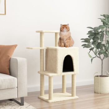 Eine flauschige orangefarbene Katze sitzt auf einem cremefarbenen Katzenbaum mit einem gemütlichen Versteck, neben einem hellgrauen Sofa und einer Topfpflanze.