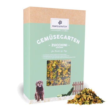 Paws & Patch 'Gemüsegarten Zucchini' Hundesnack-Schachtel mit Sichtfenster, das getrocknete Zucchinistücke zeigt, und einem Haufen daneben, mit Hundeabbildung.