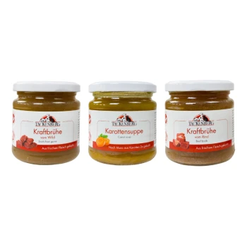 Trzy słoiki karmy Tackenberg dla zwierząt: bulion z dziczyzny, zupa marchewkowa i bulion wołowy, z białymi pokrywkami i czerwonymi etykietami.