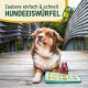 Ein Hund sitzt auf einer Holzterrasse neben einem Tablett mit knochen- und sternförmigen gefrorenen Leckerlis und einer Getränkedose mit der Aufschrift "The Dog."