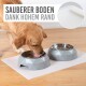 Ein Golden Retriever Hund trinkt aus einer grauen geometrischen Haustierschüssel auf einer weißen Matte, mit dem Text "SAUBERER BODEN DANK HOHEM RAND" darüber.