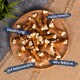 Ein Holzbrett mit knochenförmigen Hundeleckerlis, beschriftet auf Deutsch: "Belohnung," "gut bekömmlich," "calciumreich," und "sehr fettarm."