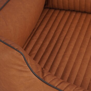 Eine Nahaufnahme eines luxuriösen braunen Haustierbettes mit einem gesteppten Design und weichem, strukturiertem Stoff mit schwarzem Rand.