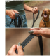 Eine Person hält zwei schwarze Hundeleinen, mit einem glücklichen braunen Hund im Hintergrund, der die Textur und das Design der Leinen zeigt.