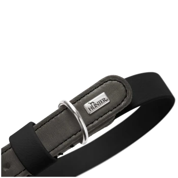 Nahaufnahme eines grauen Lederhalsbands mit schwarzem Riemen, silbernem D-Ring und Metallanhänger mit der Marke 'HUNTER'.