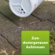 Ein schräger weißer Behälter mit einem Streuverschluss gibt lila Pulver auf Stein ab, neben einer grünen Box mit der Aufschrift "Zum dosiergenauen Aufstreuen."