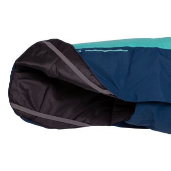 Eine Nahaufnahme einer blauen und türkisfarbenen Haustierjacke, die das Innenfutter und die Riemen für einen sicheren Sitz zeigt.