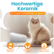 Flauschige cremefarbene Katze neben einer weißen keramischen Futterschale; deutscher Text: "Hochwertige Keramik" und "Mit Sorgfalt handgefertigt und glasiert."