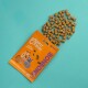 Friandises pour chiens Edgard Cooper dans un sac orange étiqueté "Bonbons," avec des chiens de dessin animé sur le devant, friandises éparpillées sur un fond teal.