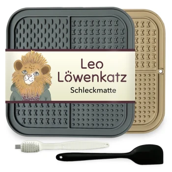 Eine Futtermatte für Haustiere mit der Aufschrift "Leo Löwenkatz Schleckmatte" mit einem Löwendesign, grauen und beigen Farben, plus einer weißen Bürste und einem schwarzen Spatel.