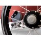 Nahaufnahme eines Fahrradrades mit einer metallischen Nabe und Speichen, vor einem roten Stoffhintergrund, der komplexe mechanische Details zeigt.
