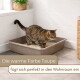 Getigerte Katze in einer taupefarbenen Katzentoilette auf gefliestem Badezimmerboden; deutscher Text: „Die warme Farbe Taupe — fügt sich perfekt in den Wohnraum ein“